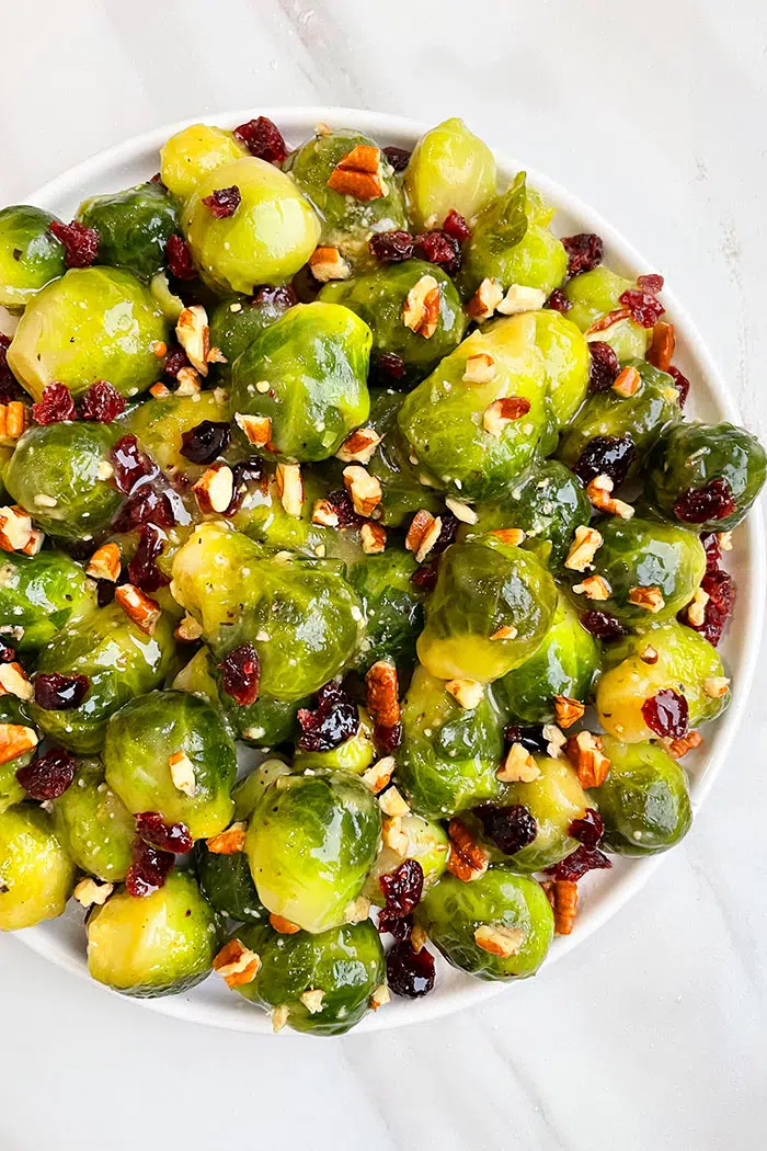 Easy Sauteed Brussels Sprouts With Pecans and Cranberries in White Plate- Overhead Shot