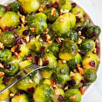 Easy Crispy Sauteed Brussels Sprouts With Pecans and Cranberries in White Plate- Overhead Shot