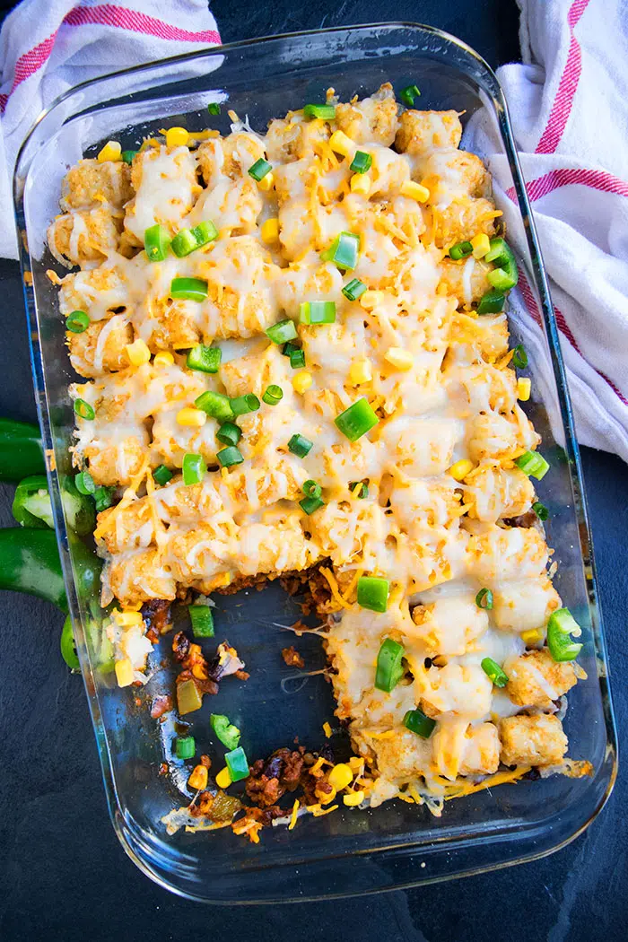 Homemade Casserole With Ground Beef and Tater Tots in Glass Dish With One Slice Removed- Overhead Shot 