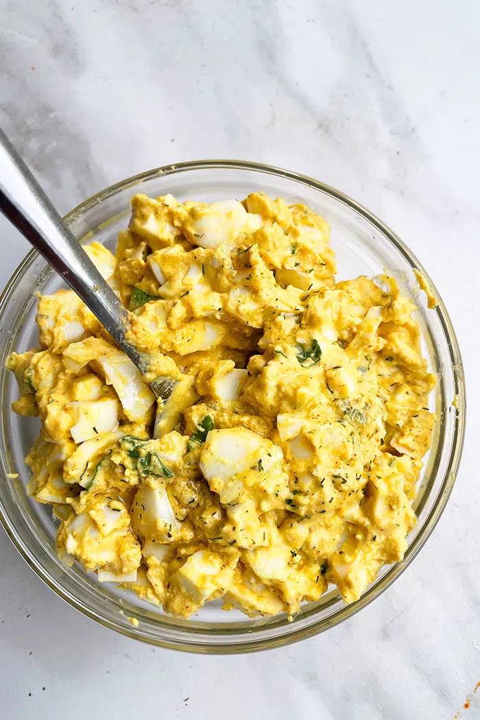 Homemade Deviled Egg Salad in Glass Bowl on Marble Background- Overhead Shot