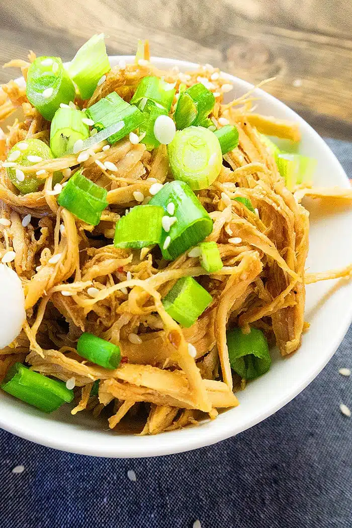 Instant Pot Shredded Honey Garlic Sesame Chicken With Spring Onions in White Bowl