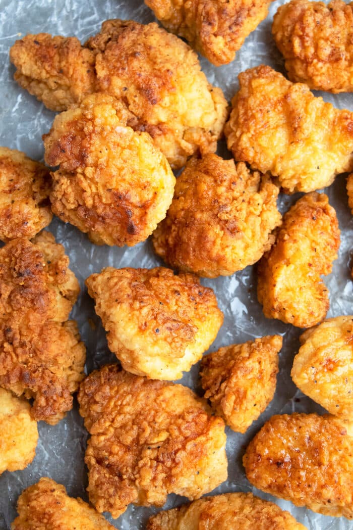 Easy crispy fried chicken bites on tray lined with crumpled paper.
