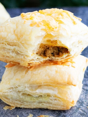 Stack of Ground Beef Puff Pastry (meat puffs or hand pies) on Rustic Gray Background.