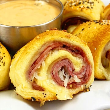 Easy Reuben Rolls Ups (Corned Beef Pinwheel Rolls) with Crescent Dough on White Plate.