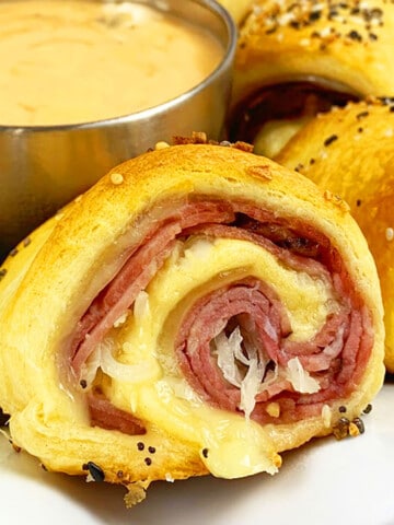 Easy Reuben Rolls Ups (Corned Beef Pinwheel Rolls) with Crescent Dough on White Plate.