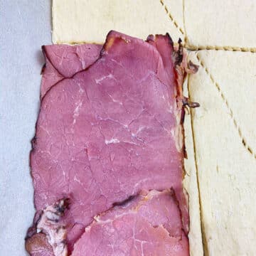 Thin slices of corned beef placed on top of cheese.