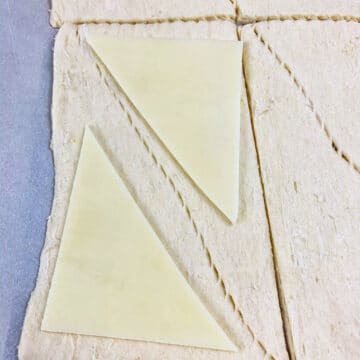 Cheese slices placed on top of rolled out crescent dough.