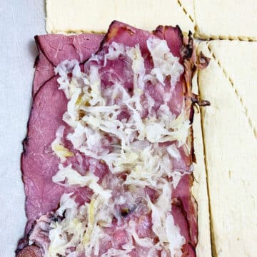 Sauerkraut spread on top of the meat.