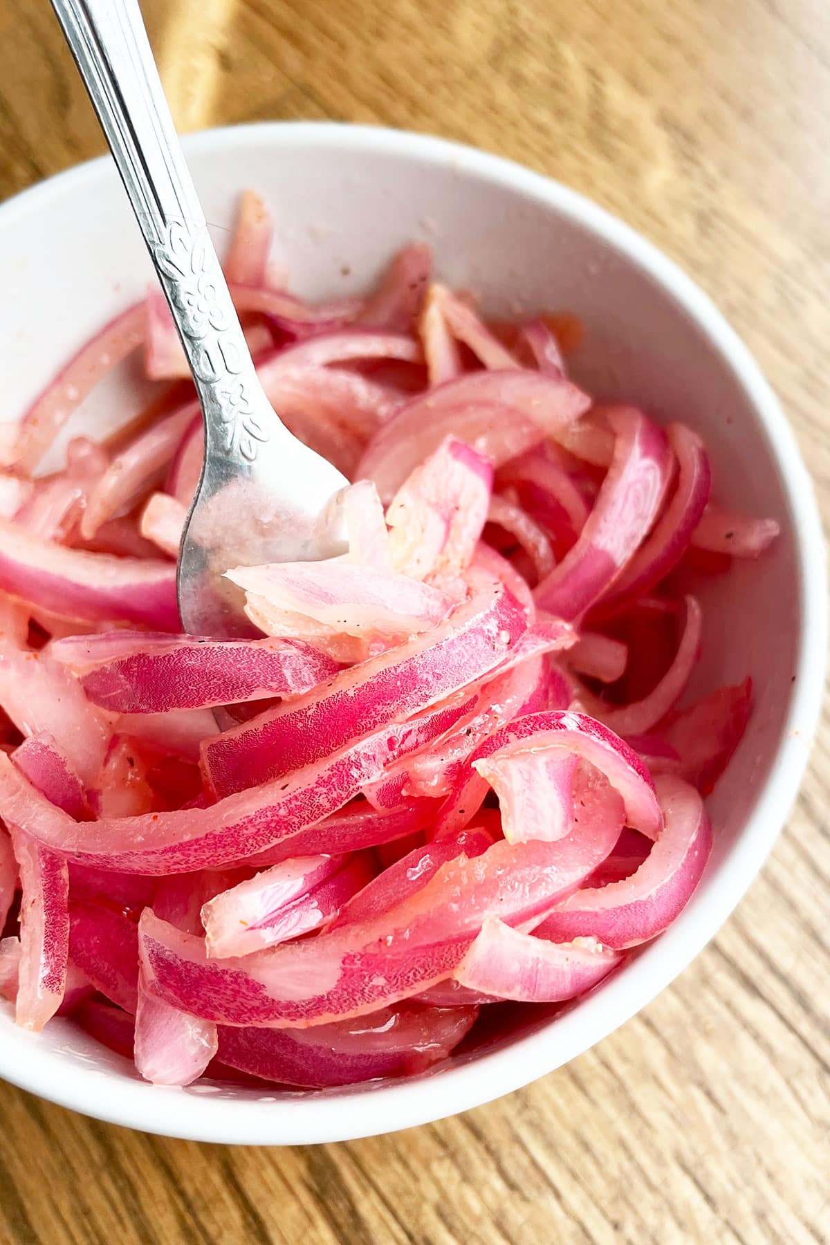 Quick Refrigerator Pickles in White Bowl With Fork on Wood Background.
