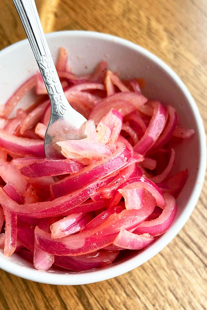 Quick Pickled Red Onions in White Bowl on Wood Background