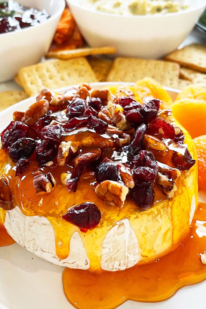 Easy Baked Brie With Jam and Cranberries on White Dish.
