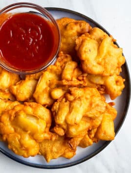 Easy Crispy Onion Fritters in White Dish With Bowl of Dipping Sauce