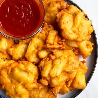 Easy Crispy Onion Fritters in White Dish With Bowl of Dipping Sauce