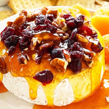 Easy Baked Brie With Jam and Cranberries on White Dish.