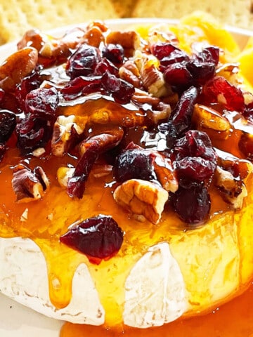 Easy Baked Brie With Jam and Cranberries on White Dish.