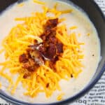 Easy Instant Pot Potato Soup With Bacon and Cheddar Cheese in Black Bowl on Newspaper