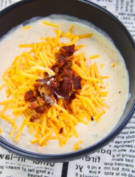 Easy Instant Pot Potato Soup With Bacon and Cheddar Cheese in Black Bowl on Newspaper