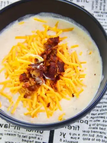 Easy Instant Pot Potato Soup With Bacon and Cheddar Cheese in Black Bowl on Newspaper