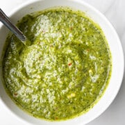 Best Easy Homemade Green Zhoug Sauce in White Bowl on Marble Background.