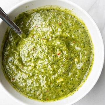 Best Easy Homemade Green Zhoug Sauce in White Bowl on Marble Background.