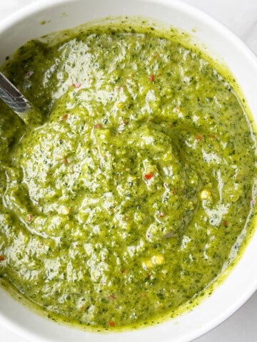 Best Easy Homemade Green Zhoug Sauce in White Bowl on Marble Background.