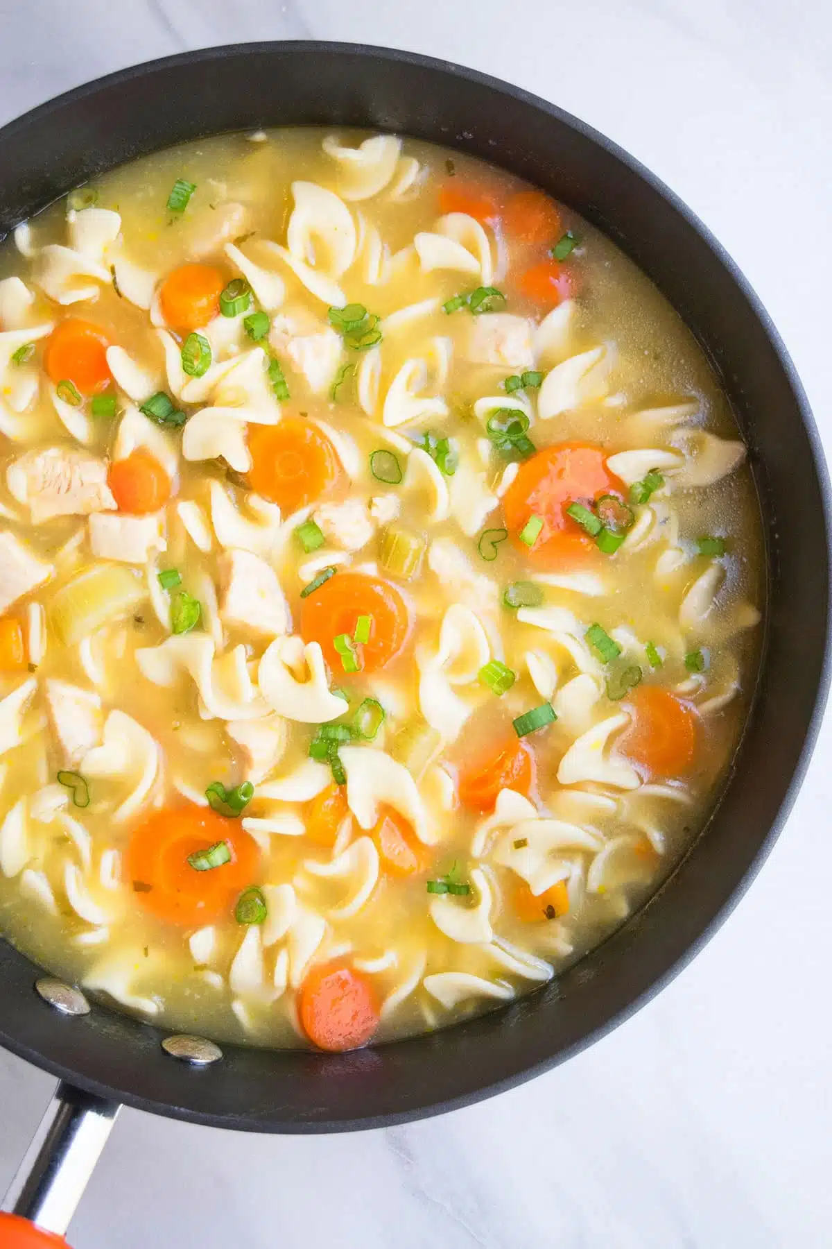 Easy Homemade Chicken Noodle Soup in Black Nonstick Pot.