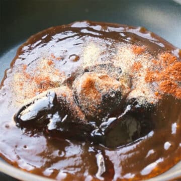 Ingredients for sauce added to black nonstick pan. 