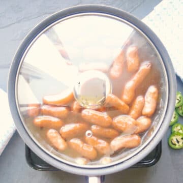 Lid covering the pan as the sausages cook. 