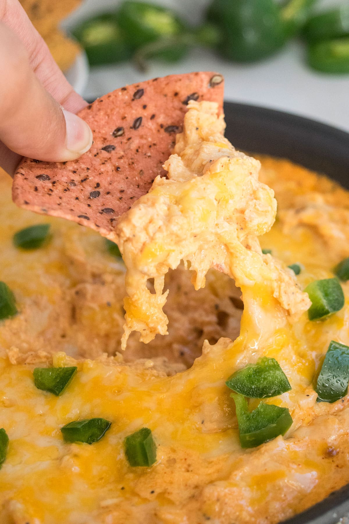 Tortilla being dunked in Easy Buffalo Chicken Dip- Closeup shot. 