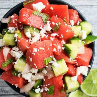 Easy One Pot Watermelon Salad With Feta Cheese in Black Bowl on Rustic Gray Background.