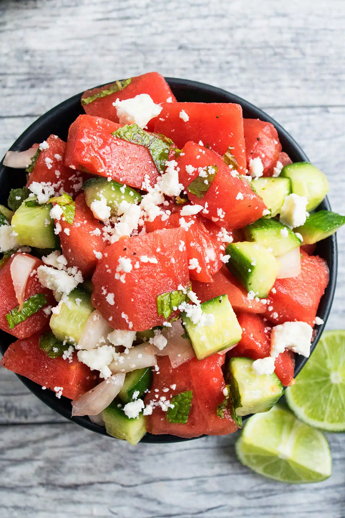 Easy Watermelon Salad With Cucumbers, Mint and Feta Cheese in Black Bowl- Overhead Shot. 