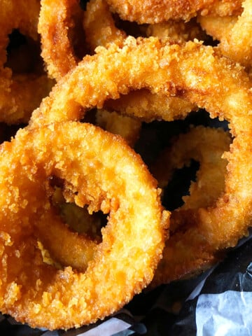 Easy One Pot Crispy Fried Onion Rings in Lined Basket.