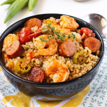 Bowl of Easy One Pot Creole Gumbo With Sausage, Shrimp, Okra Over Rice in Black Bowl.