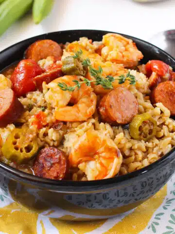 Bowl of Easy One Pot Creole Gumbo With Sausage, Shrimp, Okra Over Rice in Black Bowl.