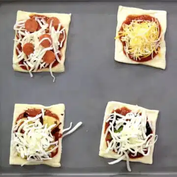 Mini square puffs with toppings on baking tray. 
