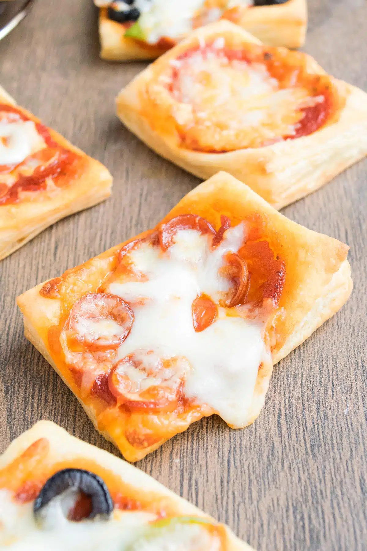 Easy mini puff pastry pizza on wood background. 