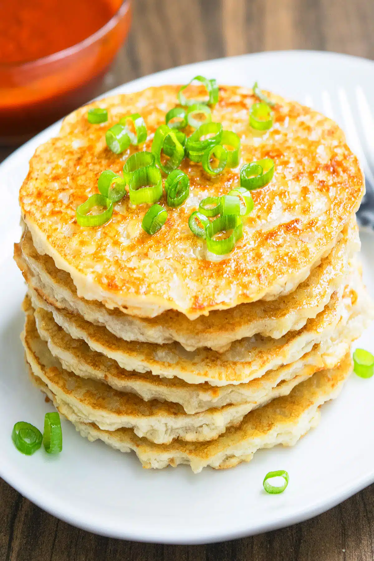 Stack of easy crispy leftover mashed potato pancakes on white dish.