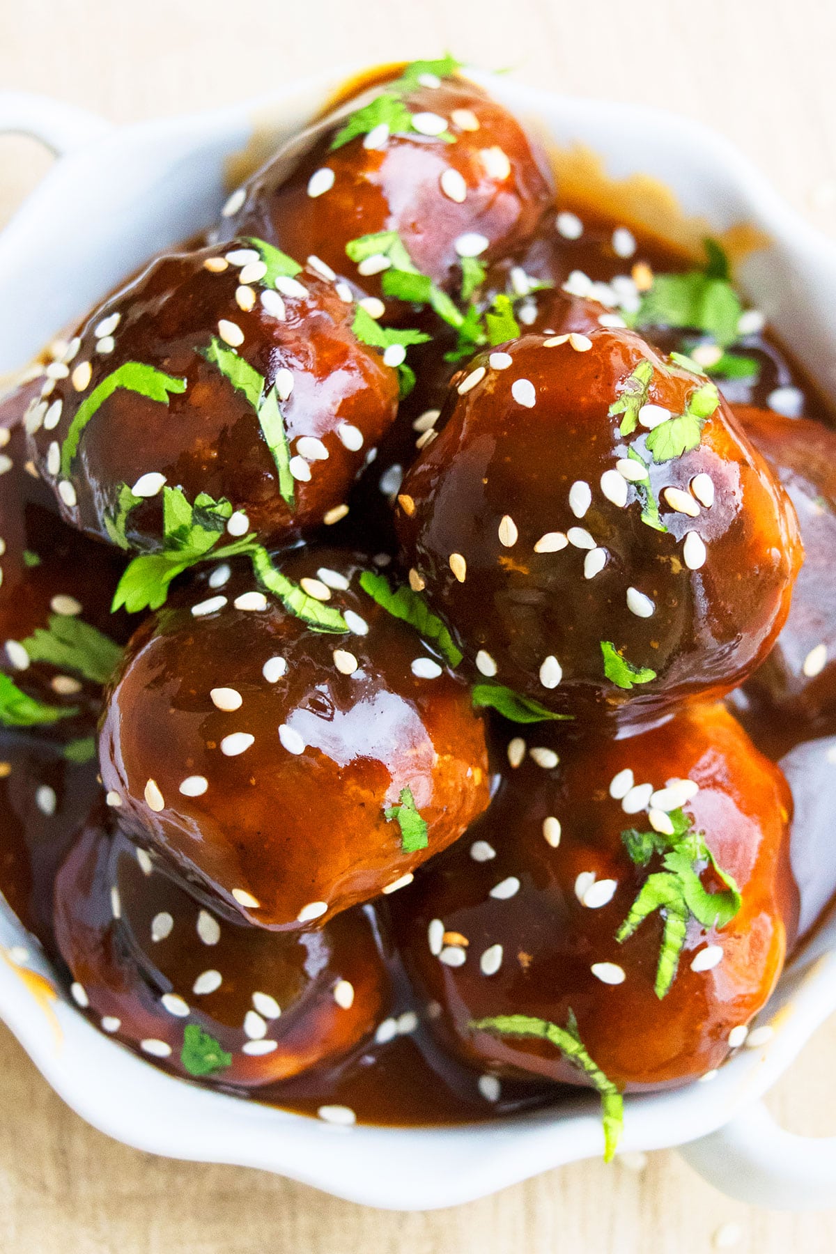 One Pot Asian meatballs in white dish garnished with green onions and sesame seeds. 