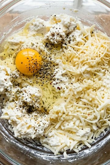 Ricotta cheese mixture about to be mixed in a glass bowl. 
