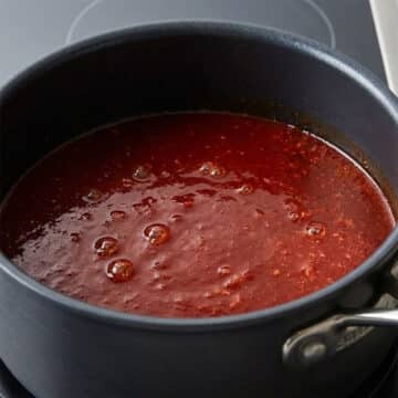 Chinese sweet and sour sauce simmering in nonstick saucepan. 