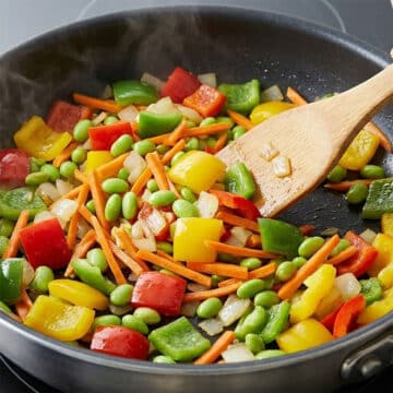 Veggies being sautéed  in nonstick pan. 