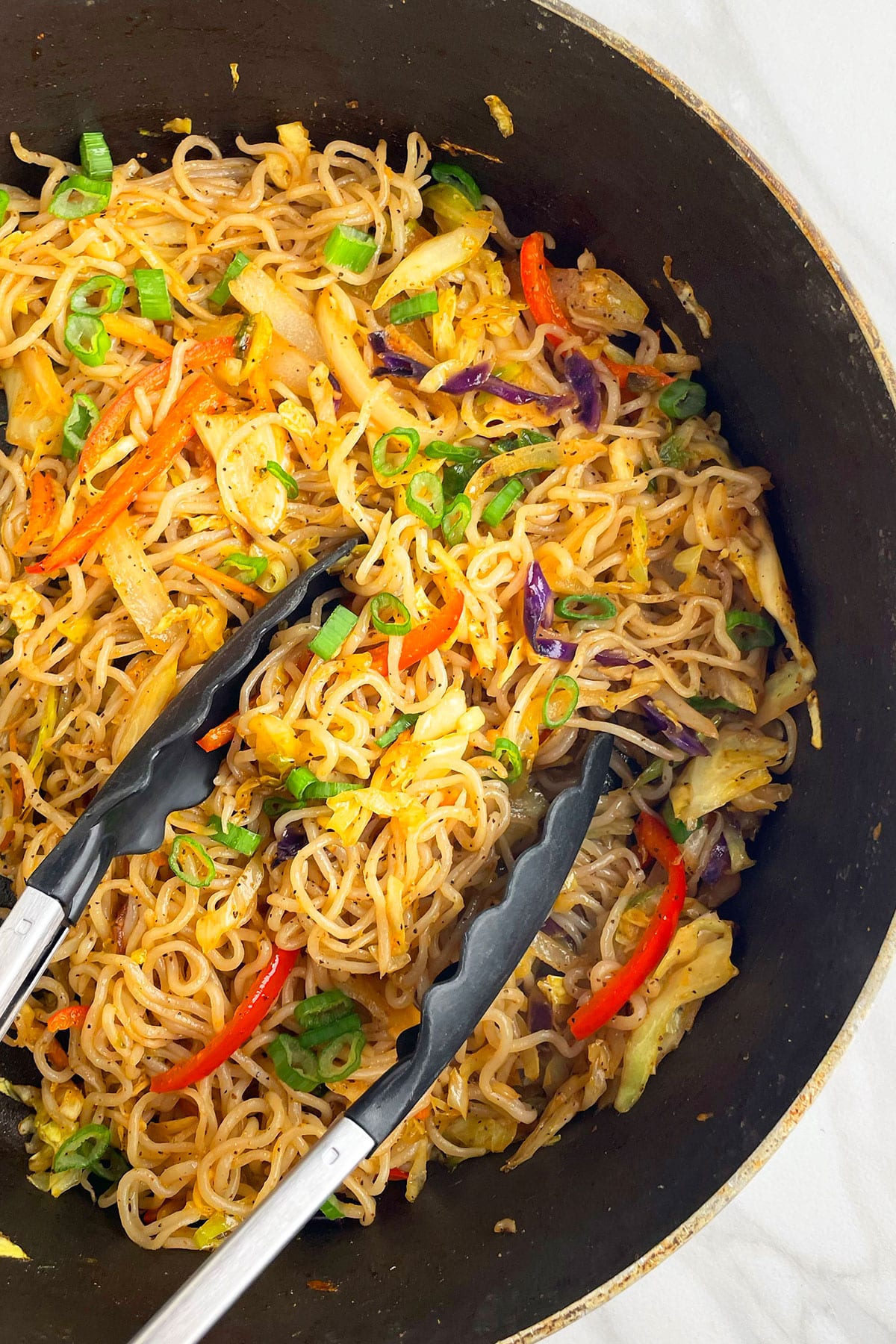 Overhead shot of vegetarian chow mein in black nonstick pot.