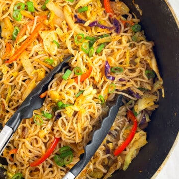 Overhead shot of vegetable chow mein in black nonstick pot.