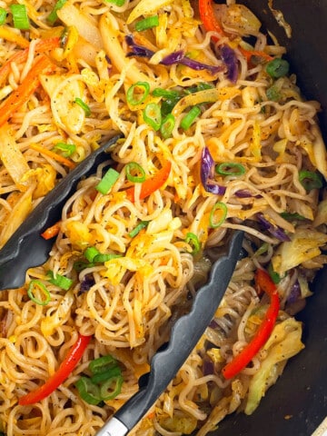 Overhead shot of vegetable chow mein in black nonstick pot.