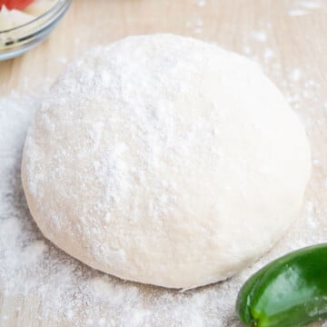 Easy 2 ingredient yogurt pizza dough on wooden tabletop.