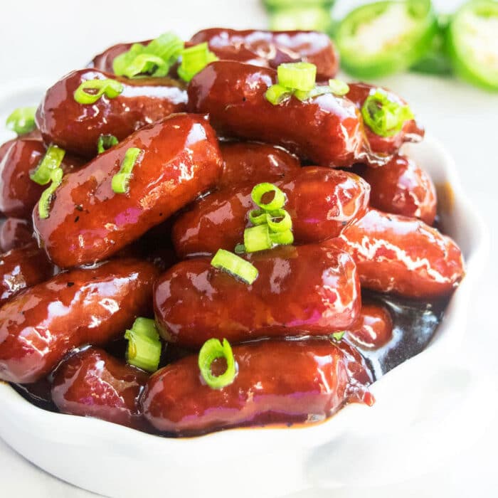 Grape jelly little smokies appetizer in white dish.