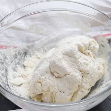 Additional flour sprinkled on top of rough dough. 