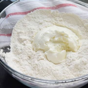 Yogurt and flour added to a glass bowl. 